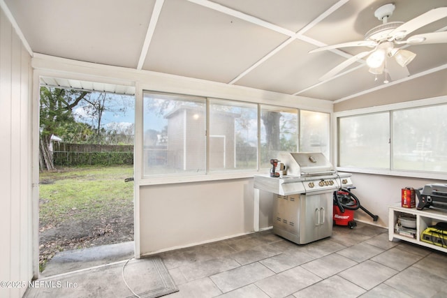 unfurnished sunroom featuring ceiling fan and a healthy amount of sunlight