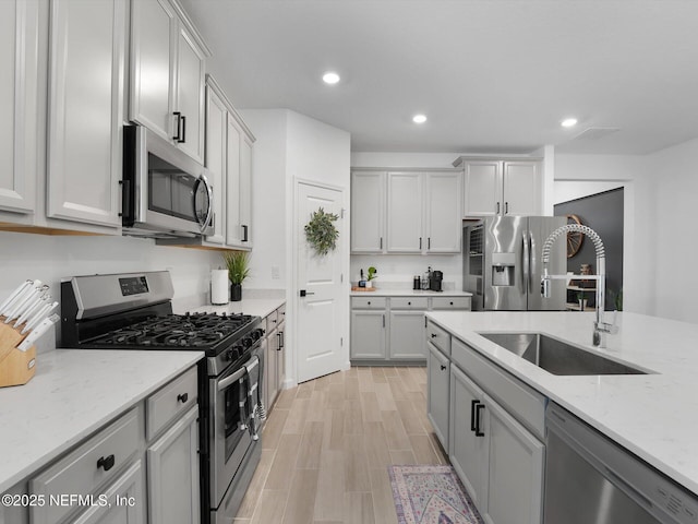 kitchen featuring light stone countertops, sink, and stainless steel appliances