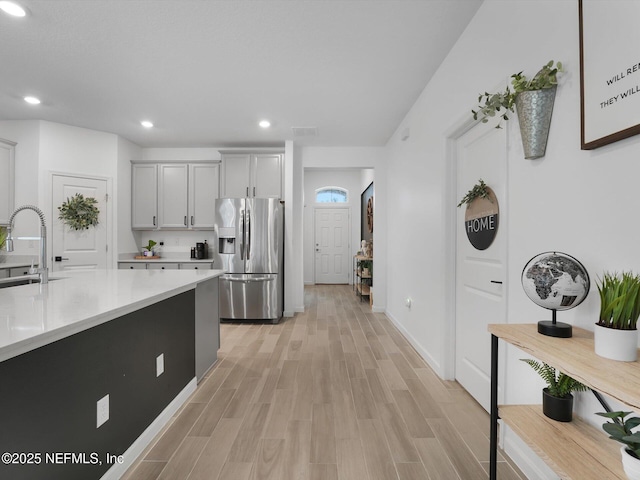 kitchen featuring light wood-type flooring, stainless steel fridge, and sink