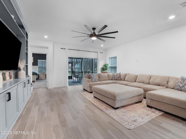 living room featuring ceiling fan and light hardwood / wood-style flooring