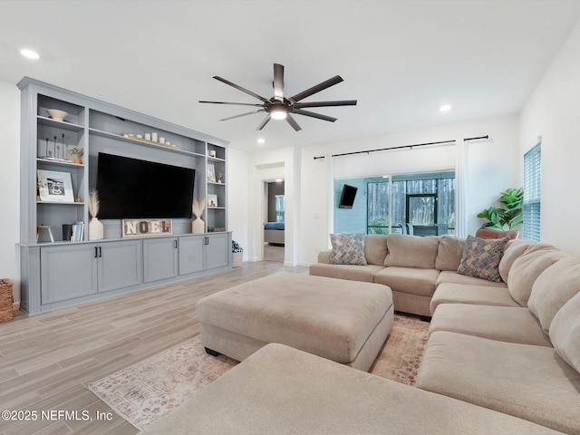 living room with ceiling fan and light hardwood / wood-style floors