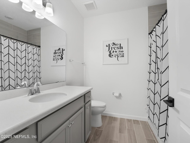 bathroom featuring toilet, vanity, curtained shower, and hardwood / wood-style flooring