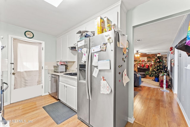 kitchen featuring white cabinets, ceiling fan, light wood-type flooring, and stainless steel appliances