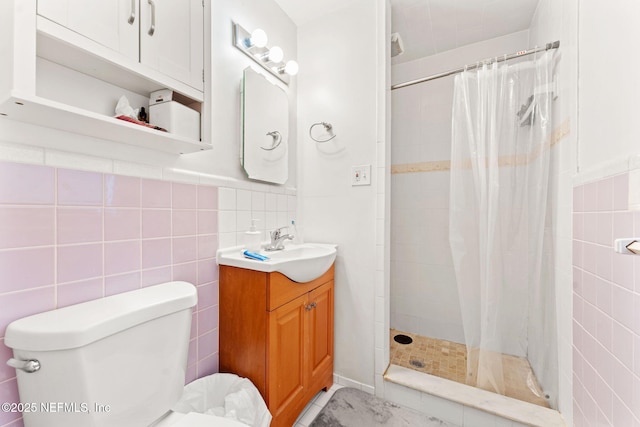 bathroom featuring vanity, toilet, curtained shower, and tile walls