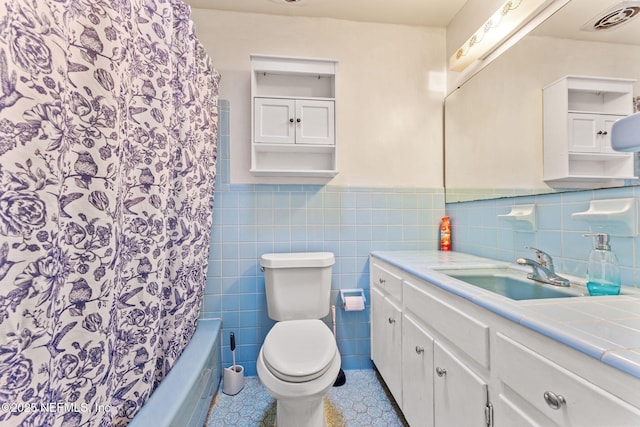 full bathroom featuring vanity, toilet, tile walls, and shower / bath combo with shower curtain