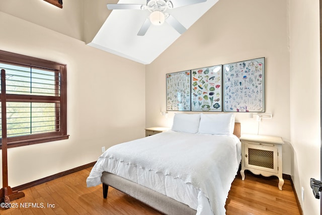 bedroom featuring hardwood / wood-style flooring, ceiling fan, baseboards, and vaulted ceiling