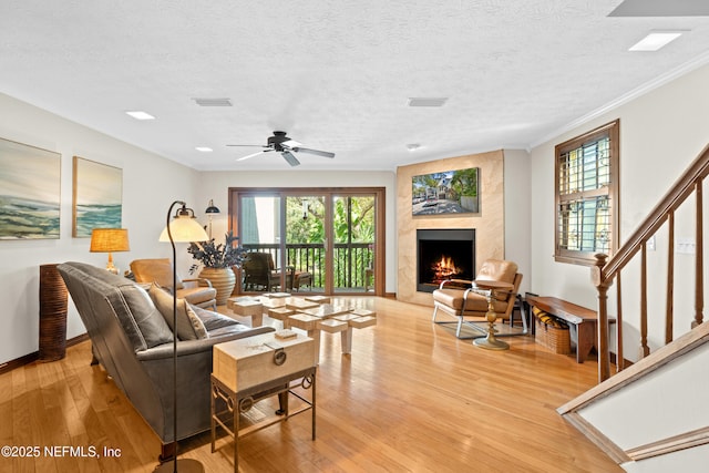 living room featuring light wood-type flooring, a healthy amount of sunlight, and visible vents