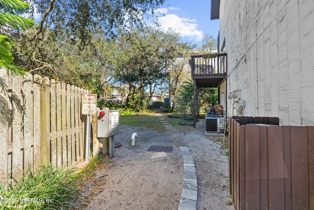 view of yard featuring fence and a balcony