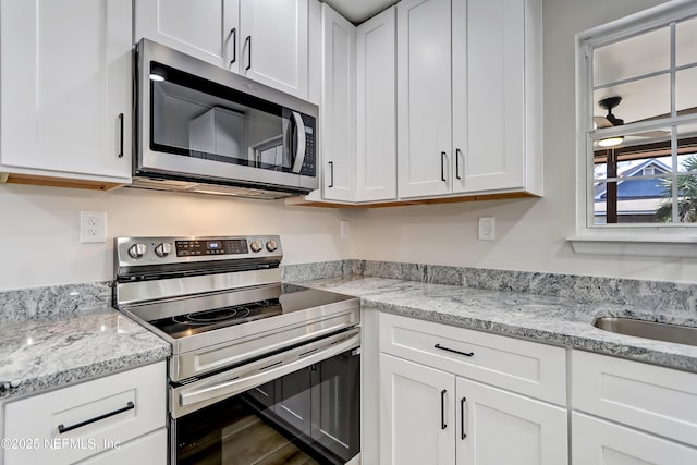 kitchen featuring stainless steel appliances and white cabinets