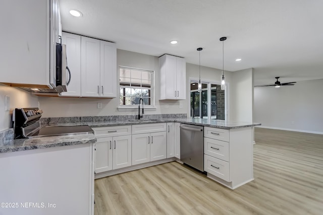 kitchen featuring appliances with stainless steel finishes, sink, hanging light fixtures, and white cabinets