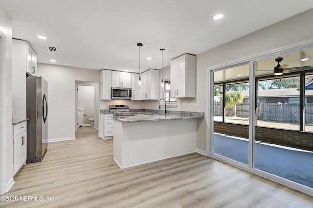 kitchen with white cabinetry, sink, hanging light fixtures, kitchen peninsula, and stainless steel appliances