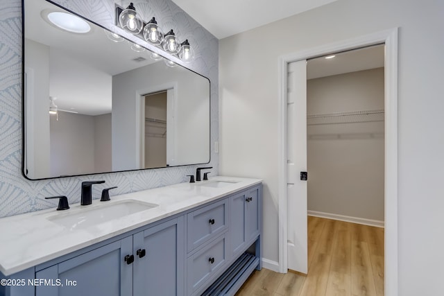 bathroom with hardwood / wood-style flooring, ceiling fan, vanity, and tasteful backsplash