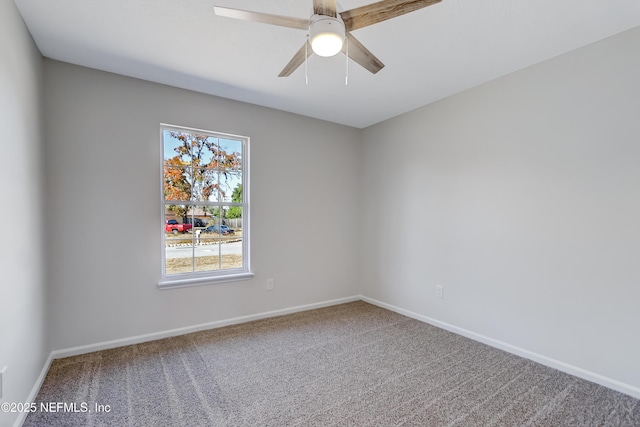 carpeted spare room with ceiling fan