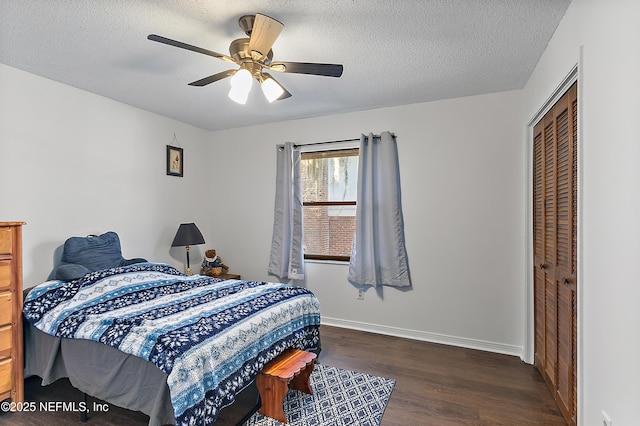 bedroom with a textured ceiling, a closet, ceiling fan, and dark hardwood / wood-style floors