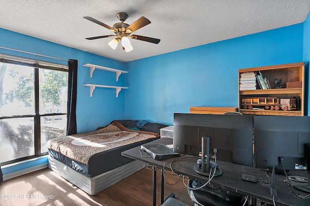 bedroom with wood-type flooring, a textured ceiling, and ceiling fan