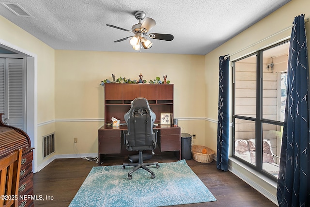 office area with a textured ceiling, ceiling fan, and dark hardwood / wood-style floors