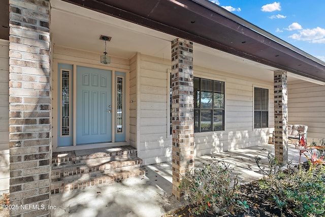 view of exterior entry featuring a porch