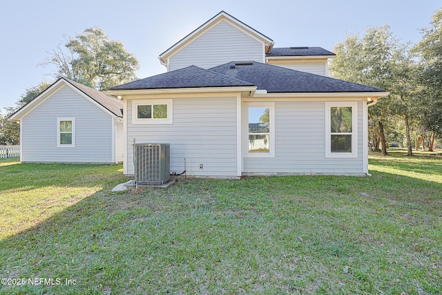 back of house featuring central air condition unit and a yard