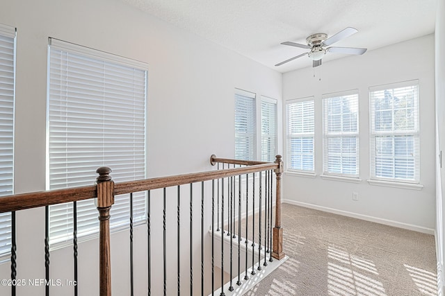 hall featuring a textured ceiling and light carpet