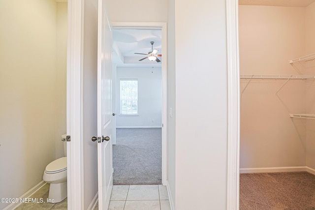 bathroom featuring toilet, ceiling fan, and tile patterned floors