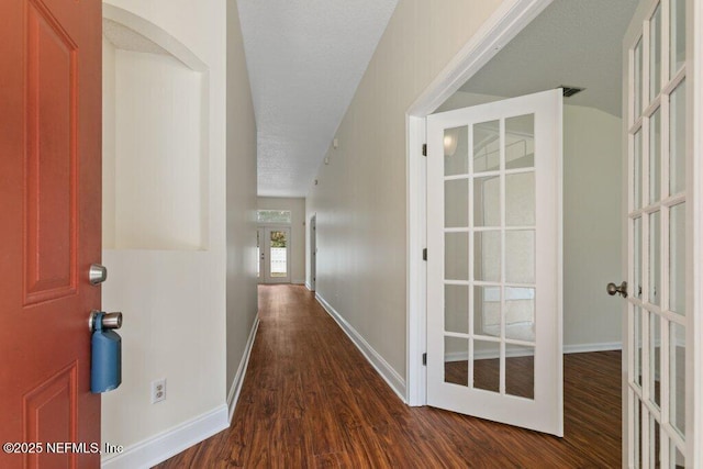 hall featuring dark wood-type flooring and french doors