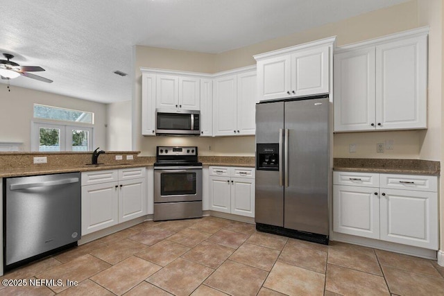 kitchen featuring ceiling fan, french doors, sink, appliances with stainless steel finishes, and white cabinets