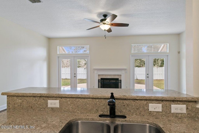 kitchen with sink, a textured ceiling, and french doors