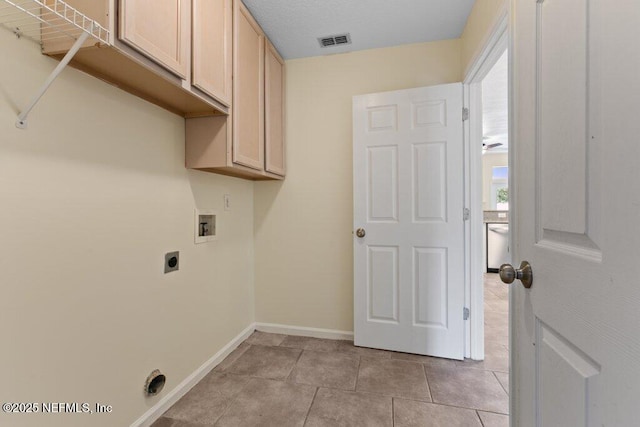 washroom featuring hookup for a washing machine, cabinets, light tile patterned floors, and hookup for an electric dryer