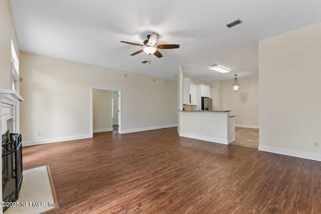 unfurnished living room with dark hardwood / wood-style floors and ceiling fan