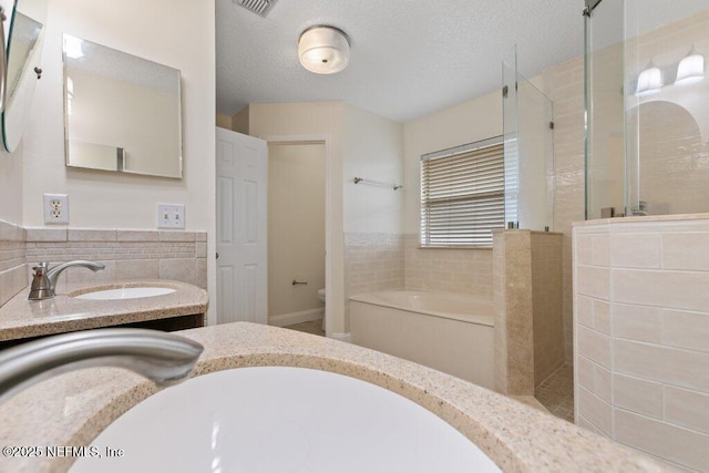 full bathroom featuring toilet, vanity, and shower with separate bathtub