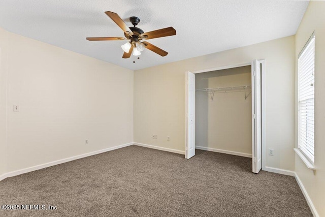 unfurnished bedroom with ceiling fan, multiple windows, and carpet