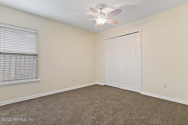 unfurnished bedroom featuring a closet, ceiling fan, and dark carpet