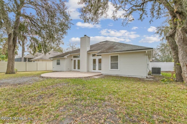 back of property with a patio area, central air condition unit, a yard, and french doors