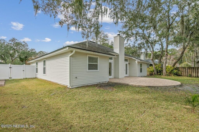 rear view of house featuring a patio and a lawn