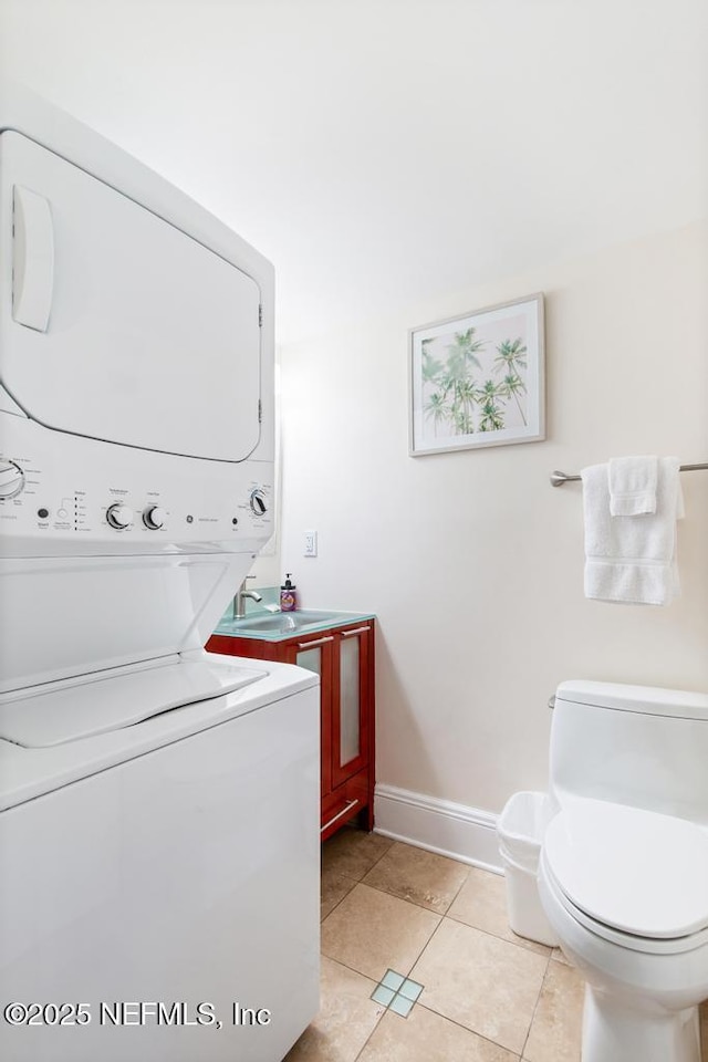 laundry room with stacked washing maching and dryer and light tile patterned flooring