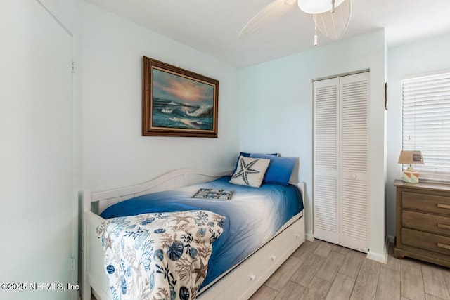 bedroom with ceiling fan, a closet, and light hardwood / wood-style floors