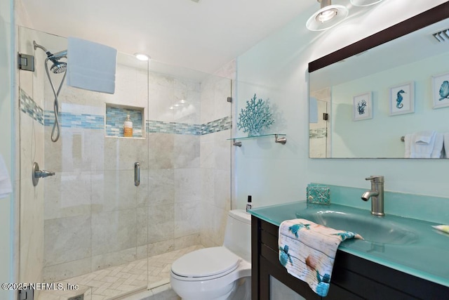 bathroom featuring toilet, vanity, and an enclosed shower