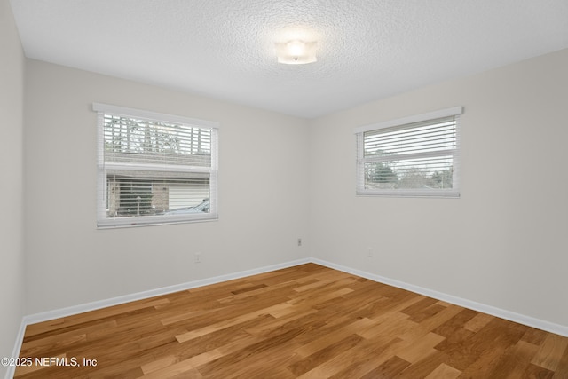 unfurnished room featuring hardwood / wood-style floors and a textured ceiling