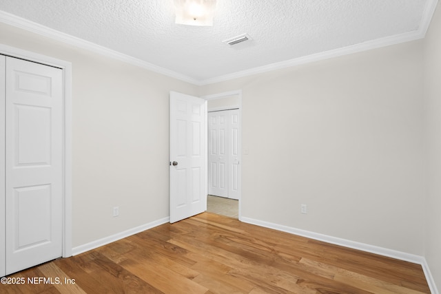 unfurnished bedroom with crown molding, wood-type flooring, and a textured ceiling