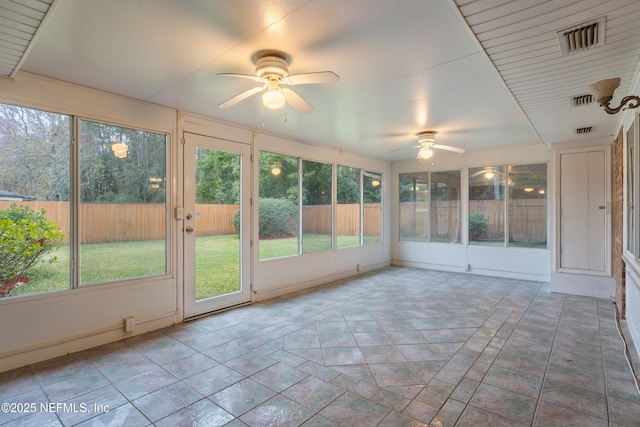 unfurnished sunroom featuring ceiling fan