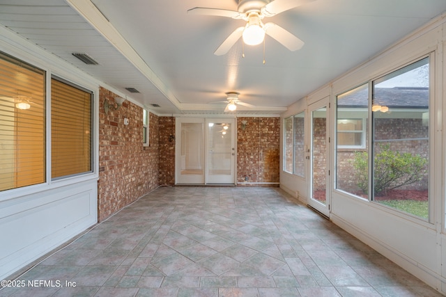 unfurnished sunroom featuring ceiling fan