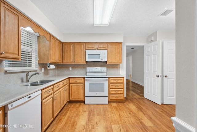 kitchen featuring white appliances, light hardwood / wood-style floors, tasteful backsplash, and sink