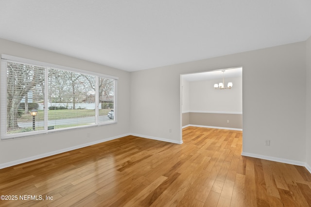 unfurnished room featuring hardwood / wood-style floors and a notable chandelier