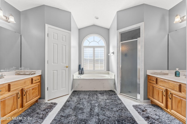 bathroom with independent shower and bath, vaulted ceiling, tile patterned floors, and vanity