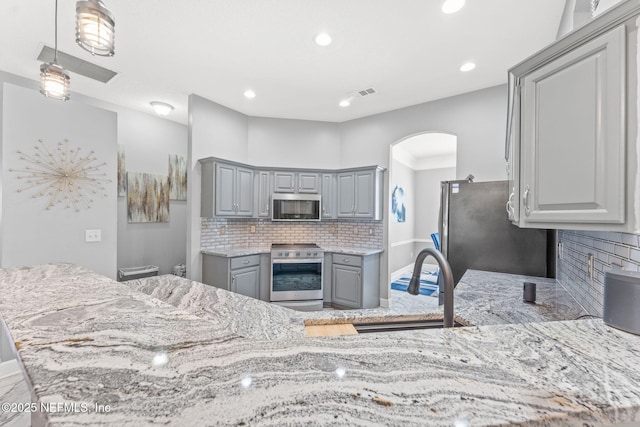 kitchen with gray cabinets, sink, decorative backsplash, kitchen peninsula, and stainless steel appliances