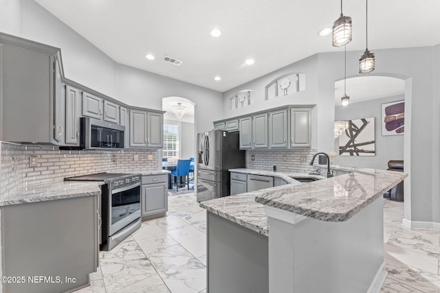 kitchen featuring sink, gray cabinets, kitchen peninsula, pendant lighting, and stainless steel appliances