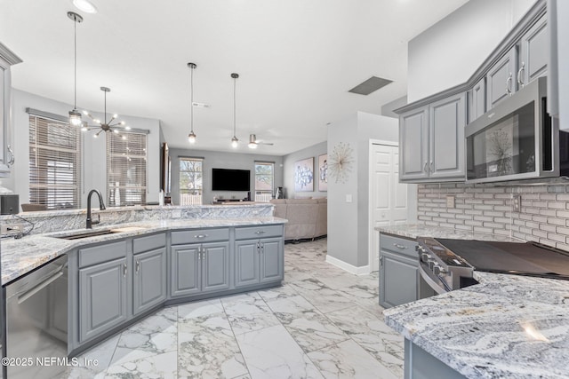 kitchen featuring gray cabinetry, pendant lighting, tasteful backsplash, and appliances with stainless steel finishes