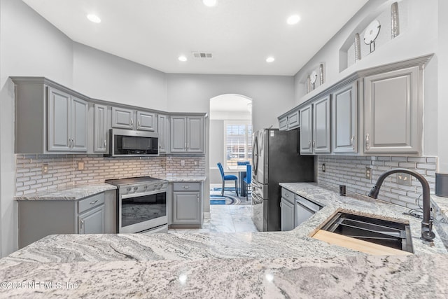 kitchen featuring stainless steel appliances, sink, and gray cabinets