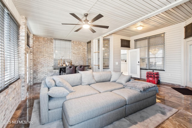 living room featuring brick wall and ceiling fan