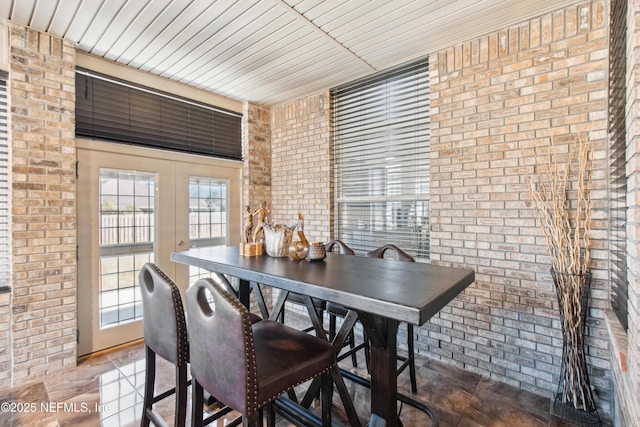 dining area featuring french doors and brick wall